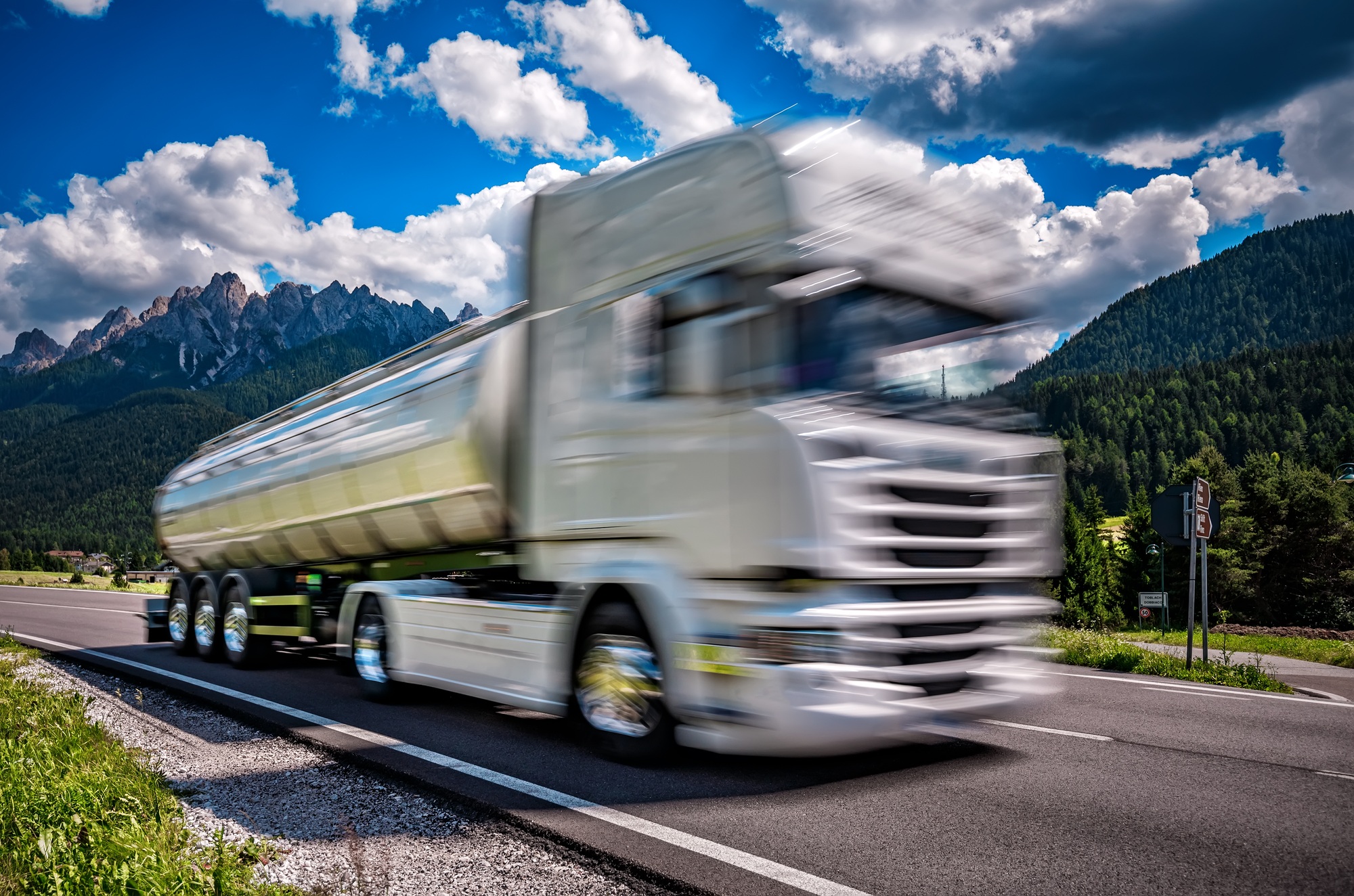 Fuel truck rushes down the highway in the background the Alps. T